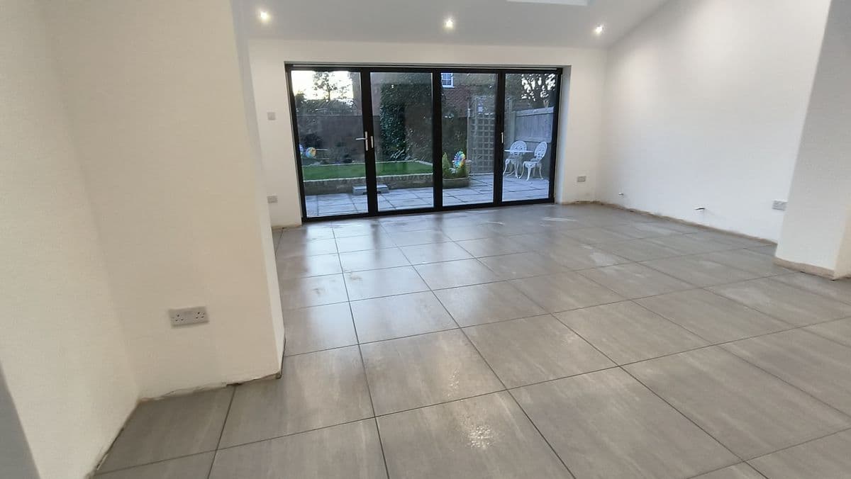 Large-format grey floor tiles across an open-plan room with bifold doors