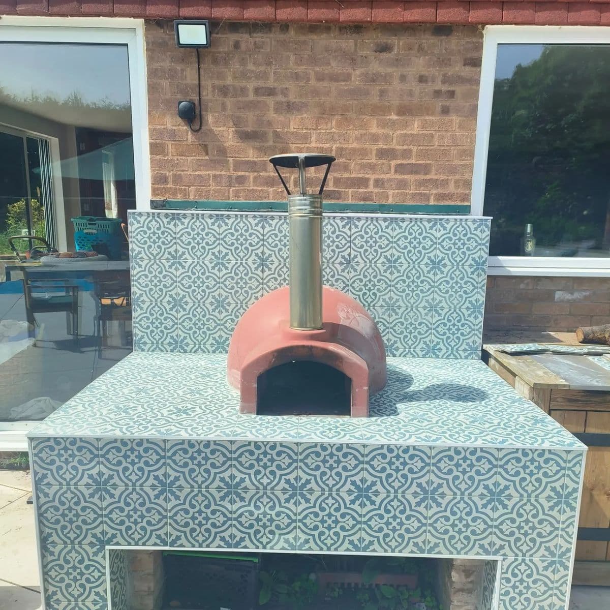 Garden pizza oven base clad in blue and white patterned tiles