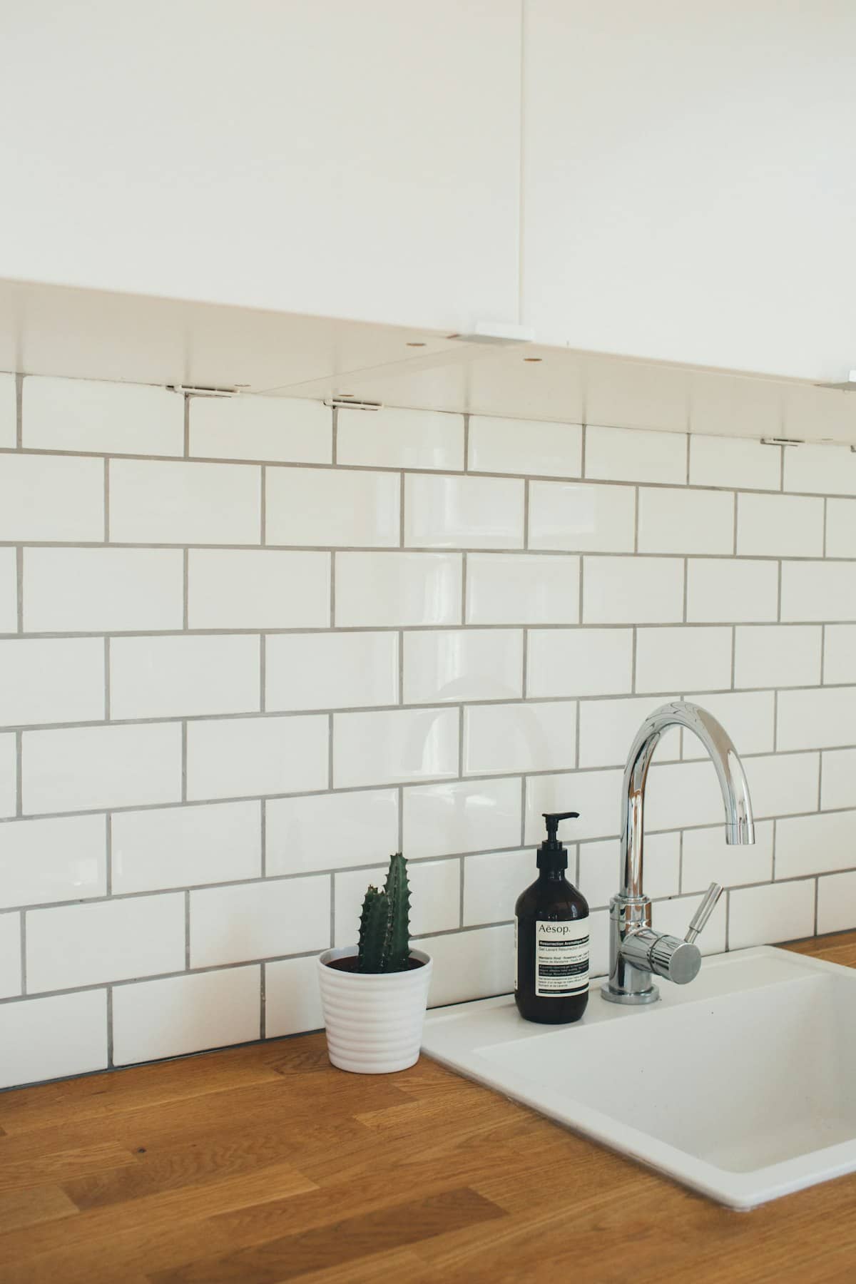 White metro tile kitchen splashback behind a sink